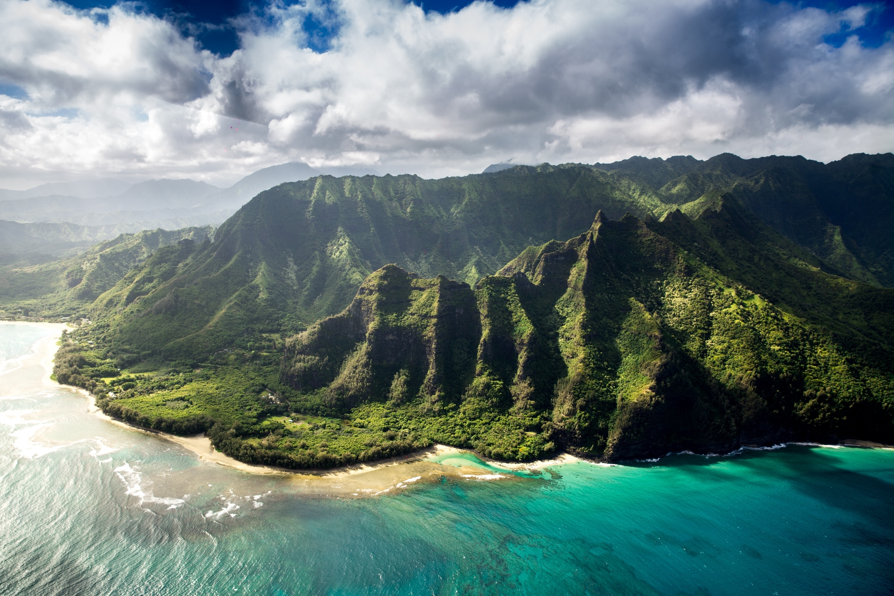 turquoise blue ocean meets the green mountains. Kauai, Hawaii is one of the best places to travel to in October