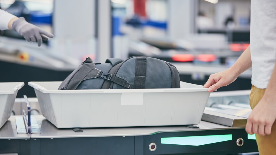 Hand luggage in a tray at airport security 
