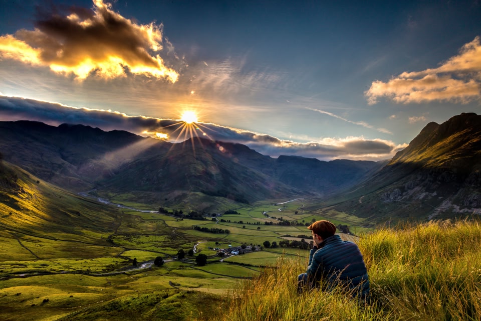 Man sitting on grass, Great Langdale, Langdale Valley, Cumbria, England.