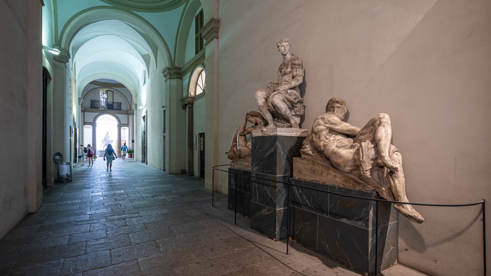 A corridor in an art museum with sculptures lining the walls
