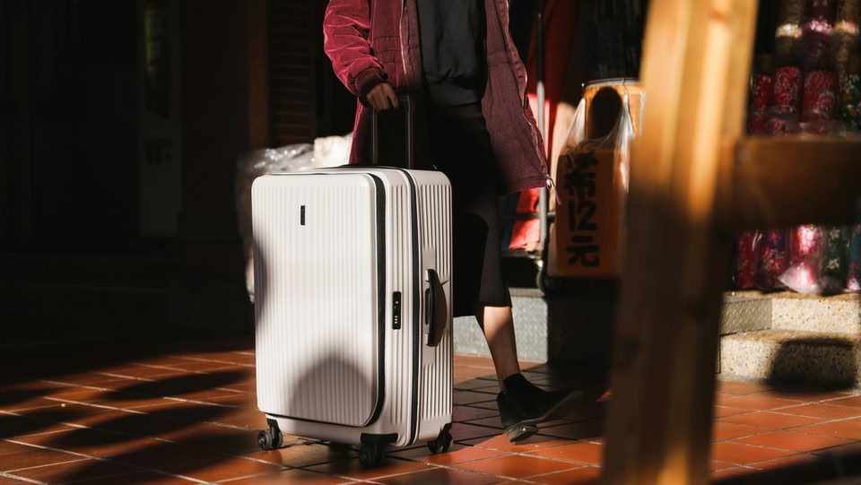 A white suit case being pulled