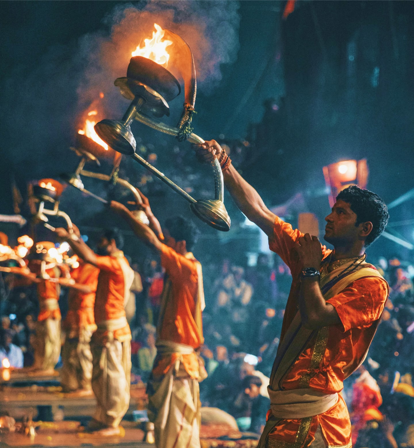 Hindu priests in Varanasi performing Ganga Aarti with flaming lamps at night.