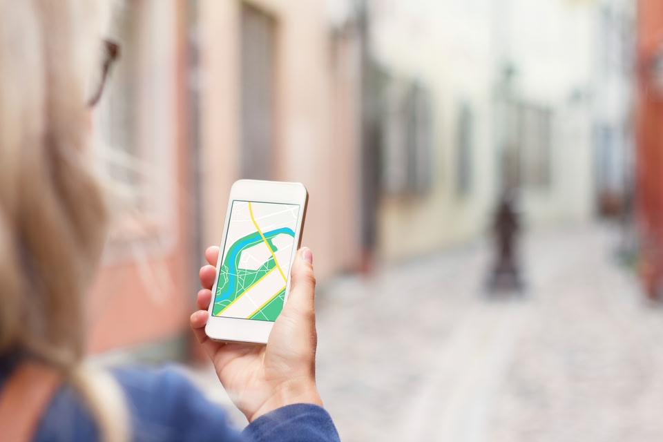 person navigating a street with an app on their smartphone