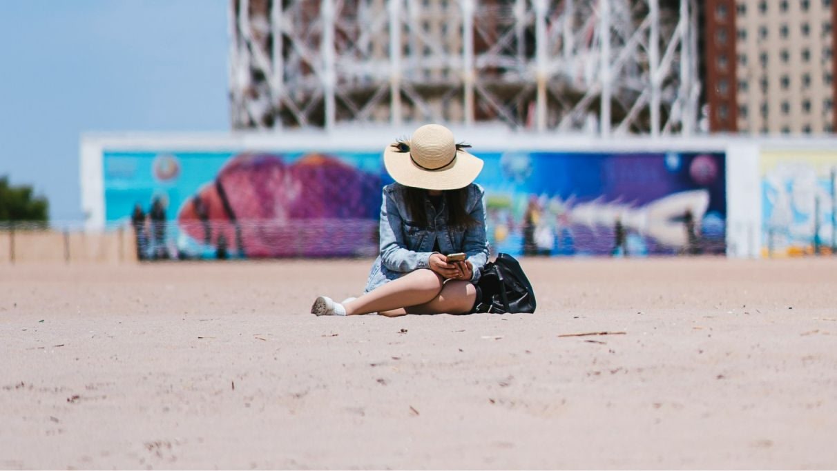 une image d'une femme assise à la plage pendant la journée