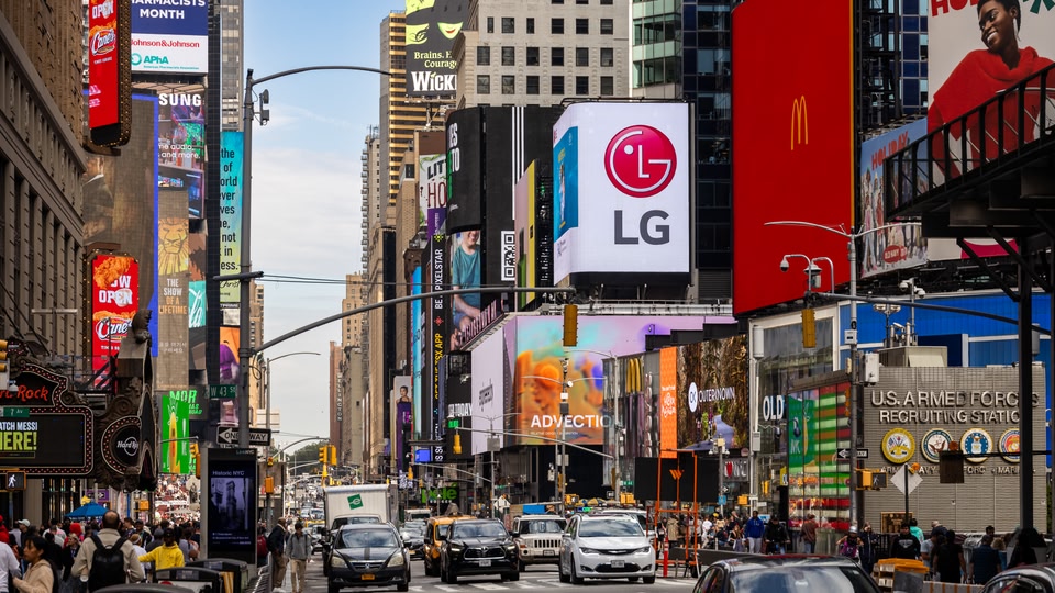 The neon lights at a busy Times Square in New York during the day