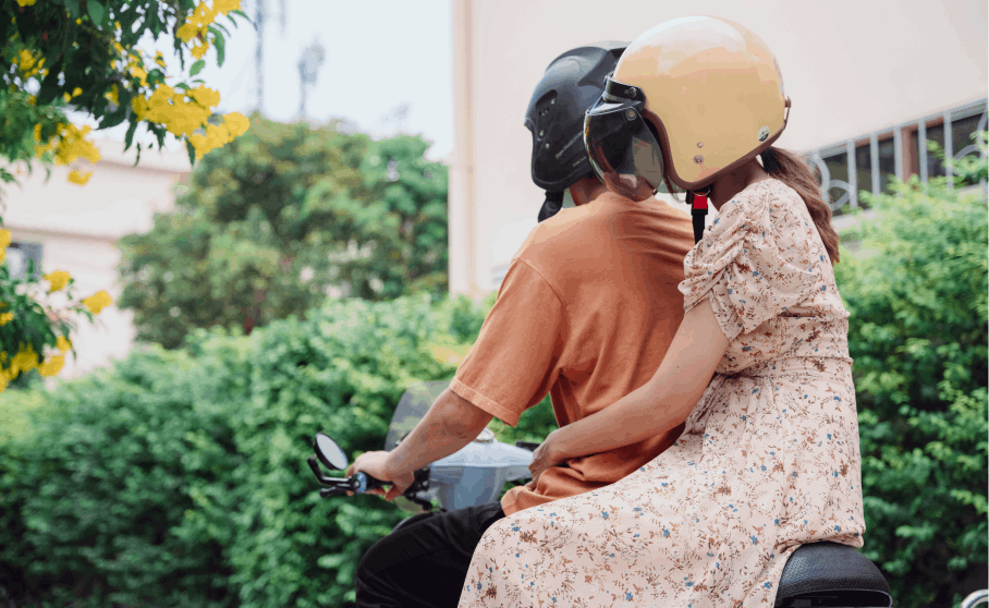  A shot of a man confidently driving a motorbike with a woman seated on the back, both immersed in the journey together