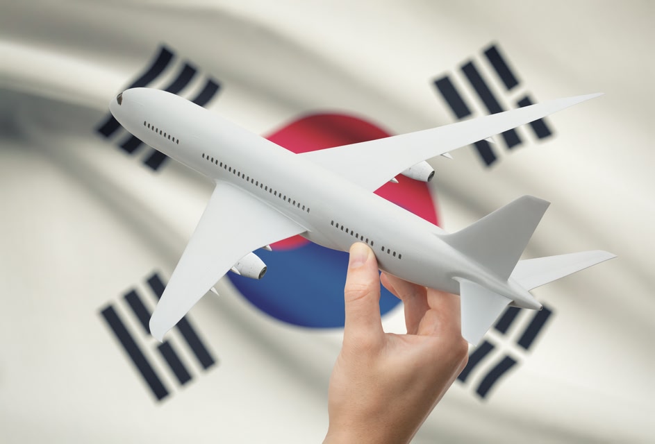 Airplane in hand with national flag on background - South Korea