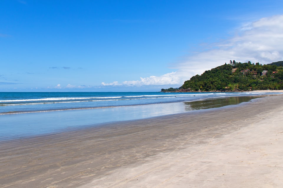 Praia da Barra do Sahy com mar, areia e montanhas ao fundo
