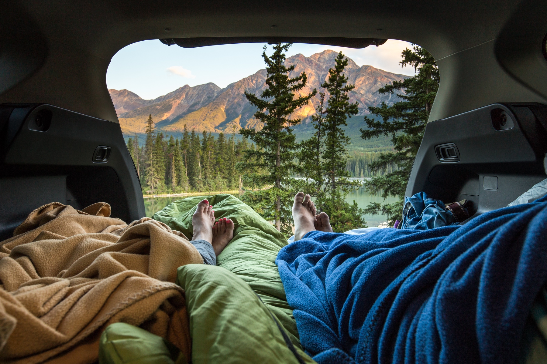 image of two peoples feet as they lay down in a tent, camping in the Canadian Rockies at Pyramid Mountain, Jasper National Park, Canada.
