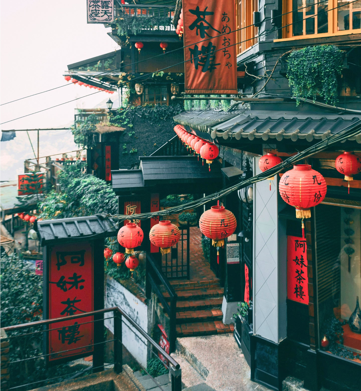 A narrow hillside street with tea houses and red lanterns glowing in Taipei, Taiwan.