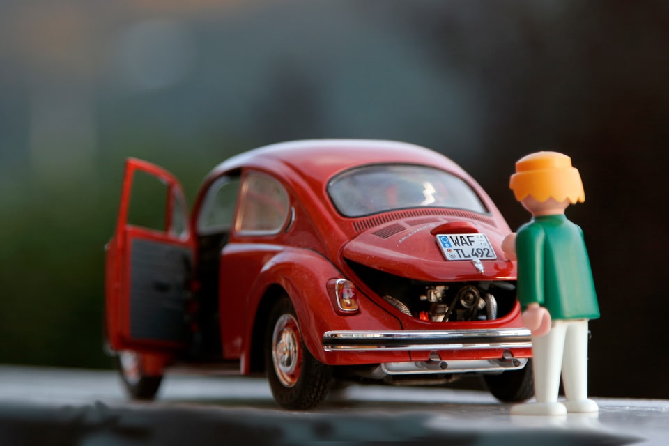 car figurine and toy closing toy car trunk before playing road trip games