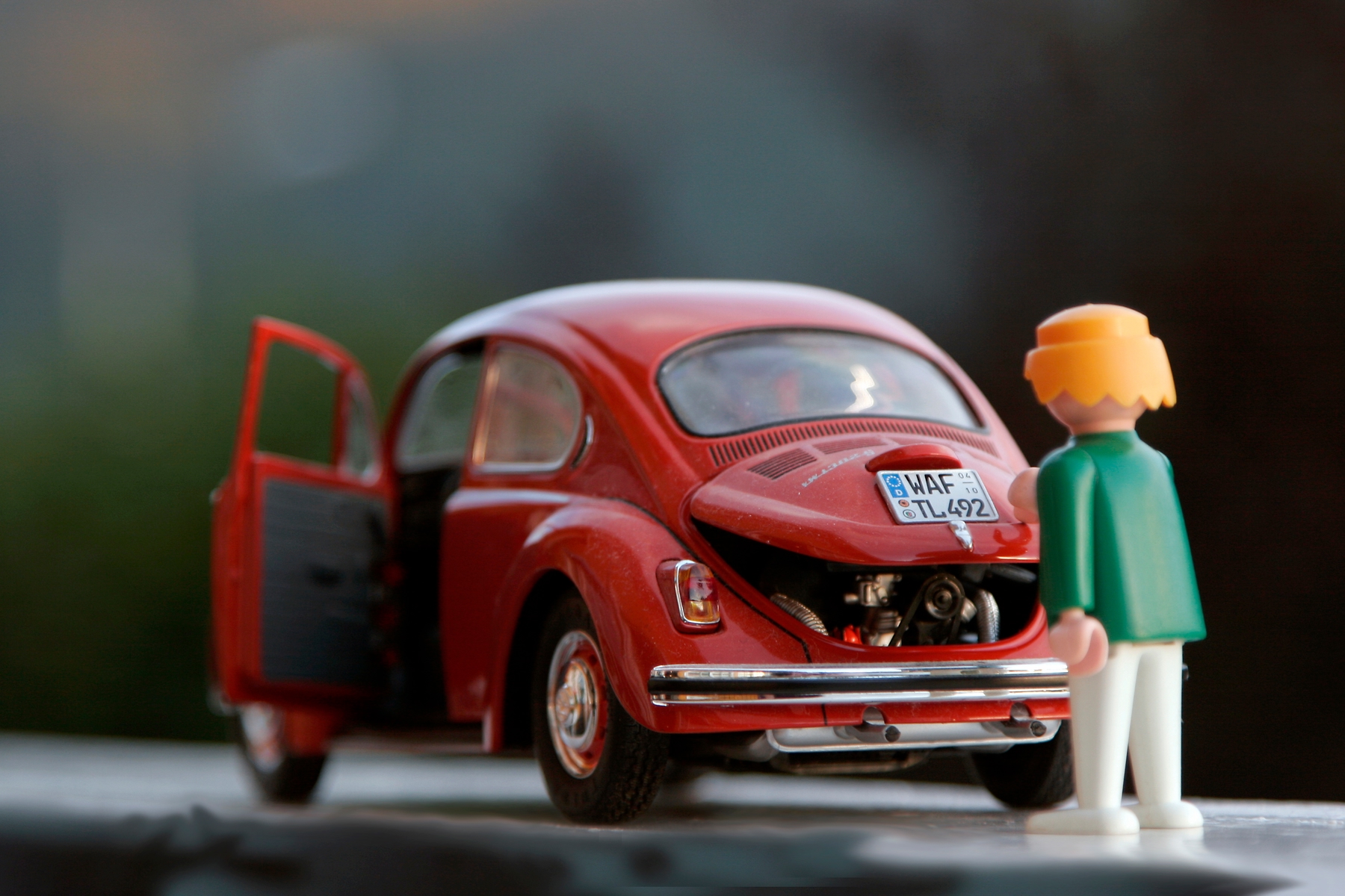 car figurine and toy closing toy car trunk before playing road trip games