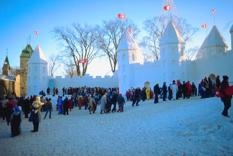 people outside of a snow sculpture castle in quebec city during a winter festival