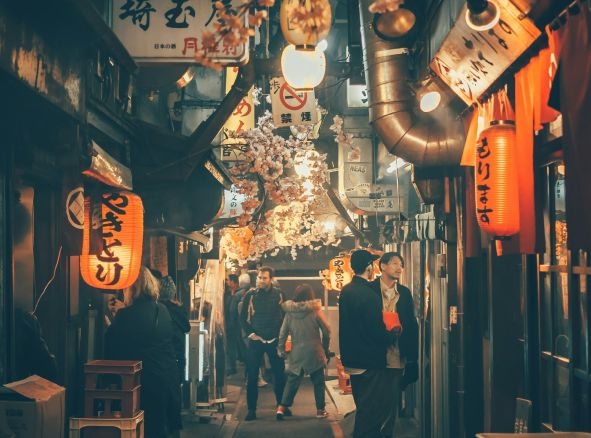 An image of a typical Japanese street with people walking during night time