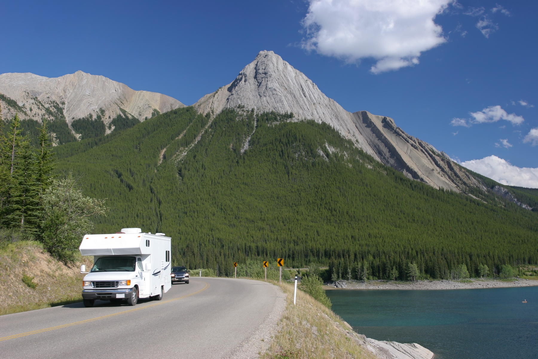 camper van driving along the highway with views of the Canadian Rockies in the distance