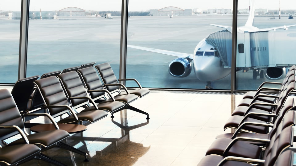 image inside an airport lounge looking out at a stationary plane