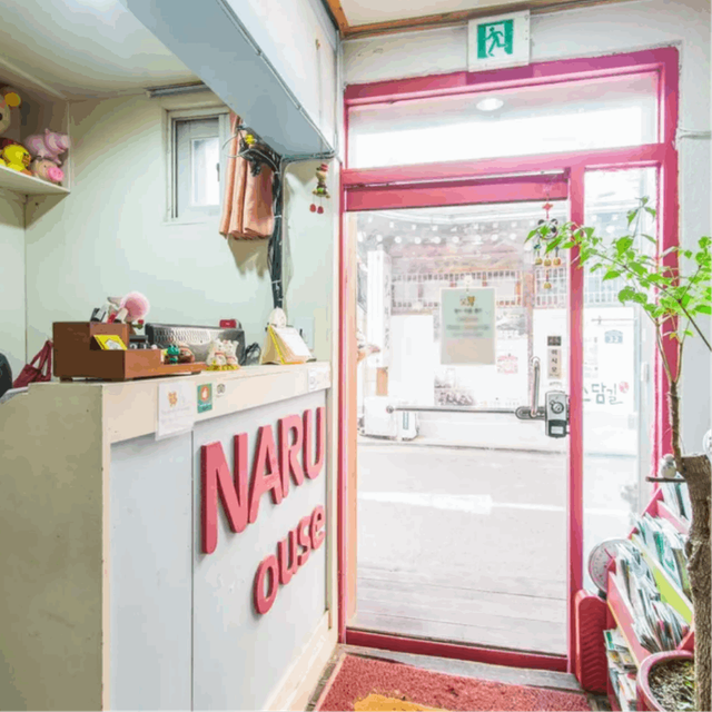 An interior shot of Naru Hostel, capturing the reception desk and entrance door.