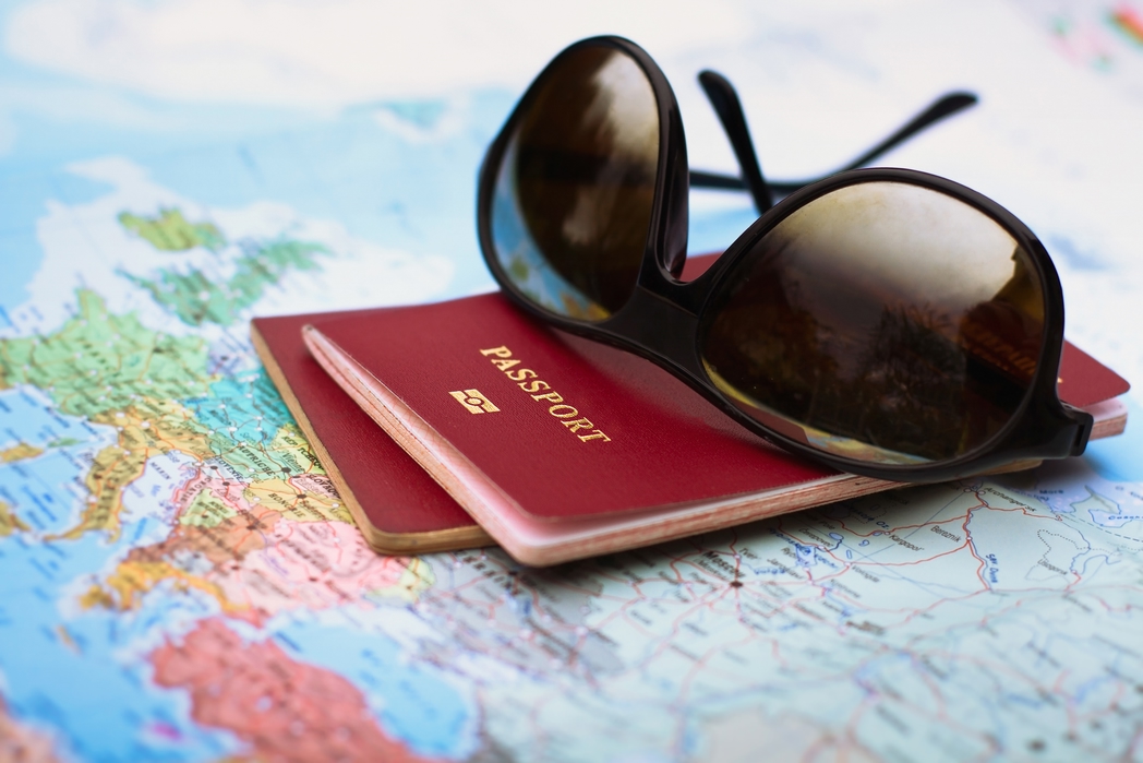 Passport and glasses on top of a map - 10 most common holiday arguments couples have