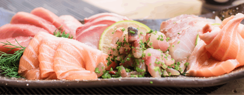 A plate of mixed sashimi including salmon and tuna.