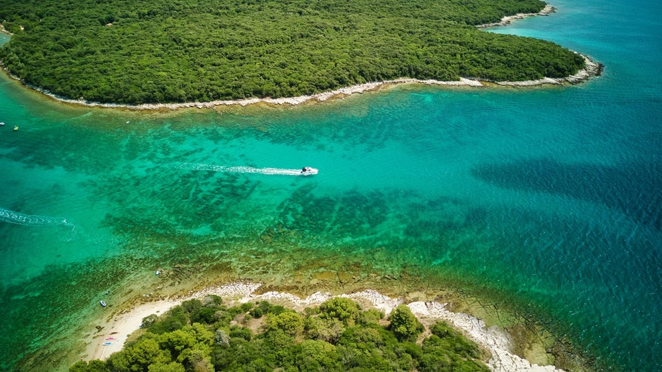 Turquoise zee met hagelwit strand in groen landschap Istrië, Kroatië