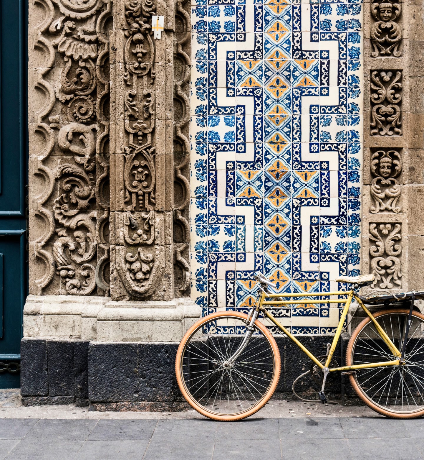 Bike leans against colourful ornate tiled wall in Mexico City
