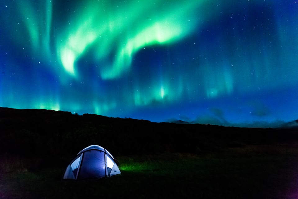 Camping in nature to catch the Northern Lights in action
