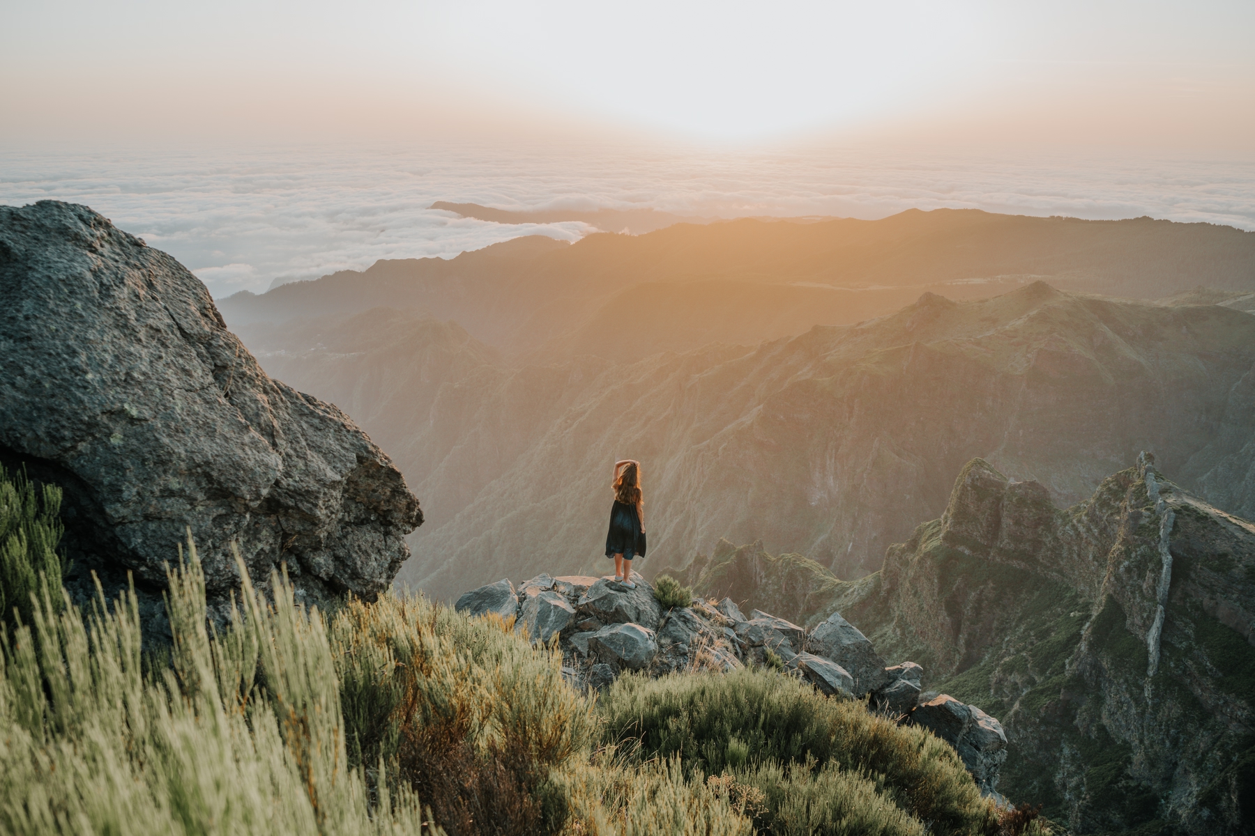 Frau bestaunt die Aussicht auf einer Wanderung während ihrer Soloreise.