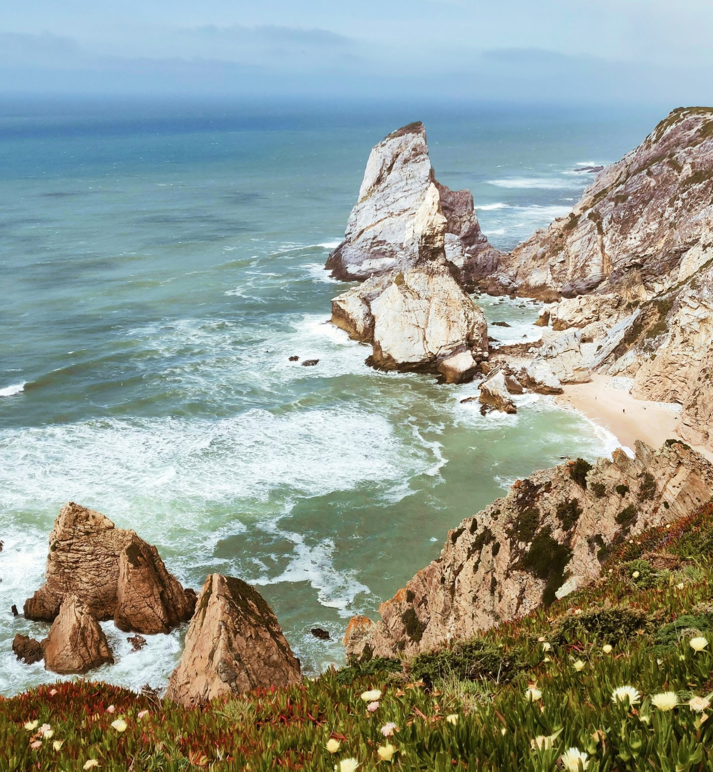Onde che si infrangono contro scogliere e faraglioni su una costa frastagliata vicino a Portimão, in Portogallo.
