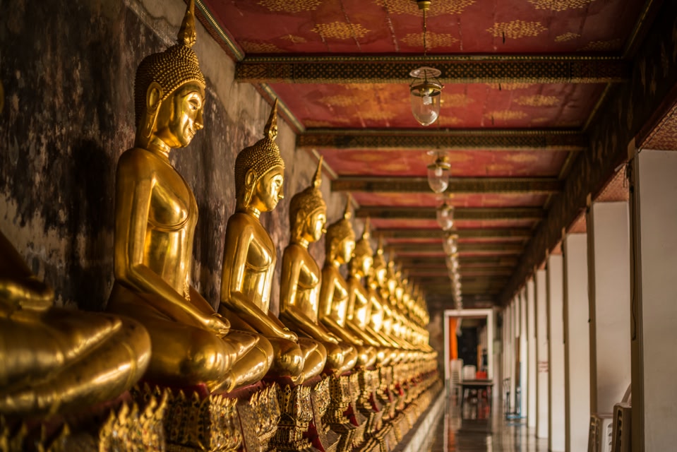 Row of golden Buddha statues in Bangkok
