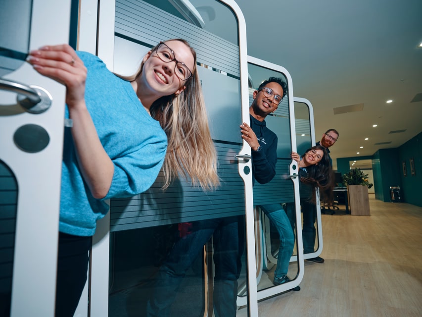 Team members poking their heads out of call booths