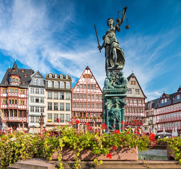 Römerberg historic square in Frankfurt, with guildhouses in the background and a statue of justice in the foreground.