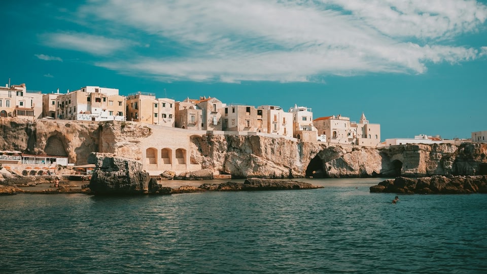 Polignano a Mare, città costiera con edifici in pietra costruiti su scogliere rocciose che si affacciano sul mare.
