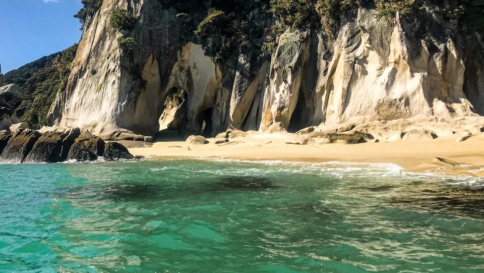Spiaggia con scogliere e acqua turchese.