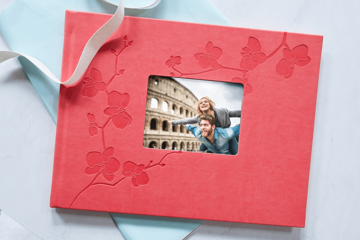 Photo book front cover with window showing couple exploring the colosseum.