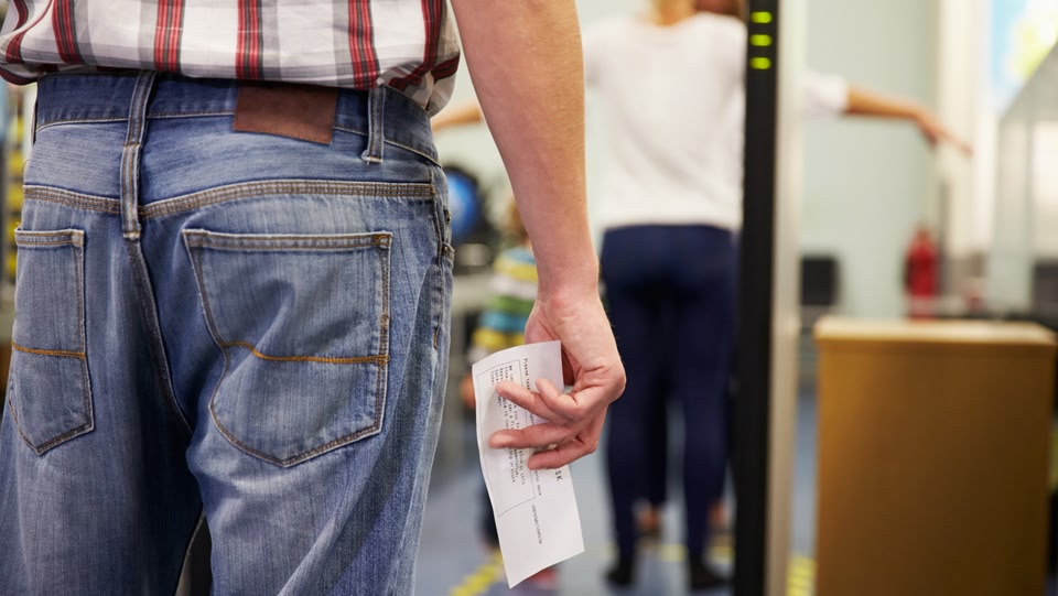 Man met instapkaart wacht bij security check