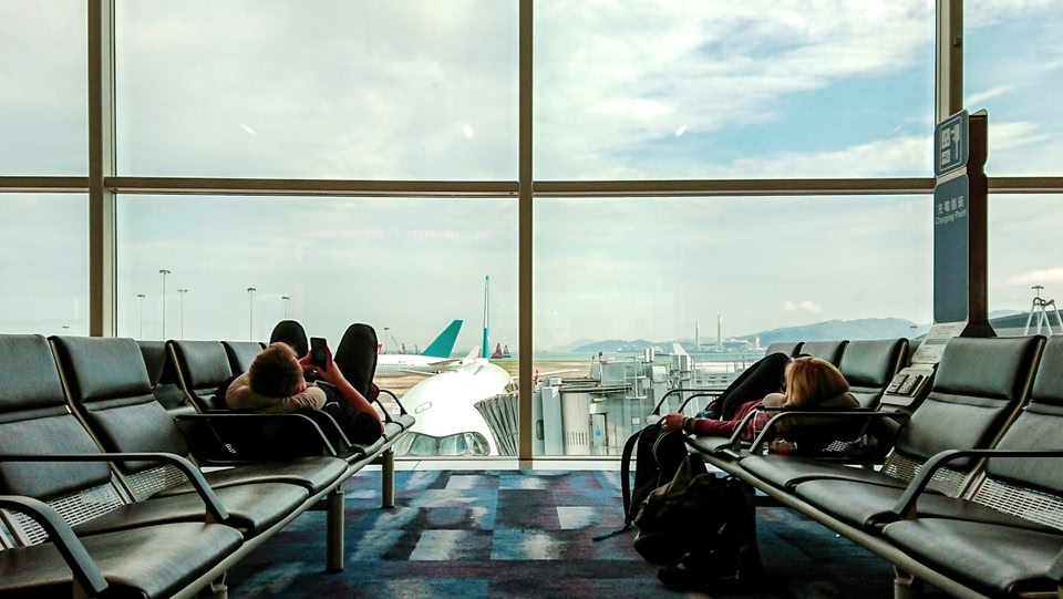 Mensen liggen op stoelen in de vertrekhal op luchthaven