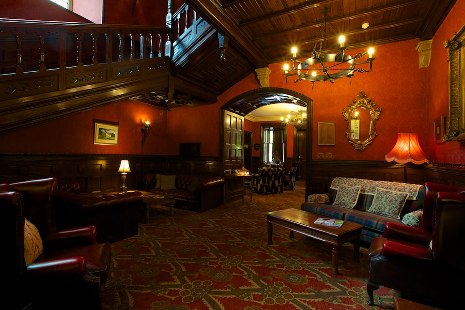 Reception hall of Tulloch Castle, with dark wood and moody lighting.