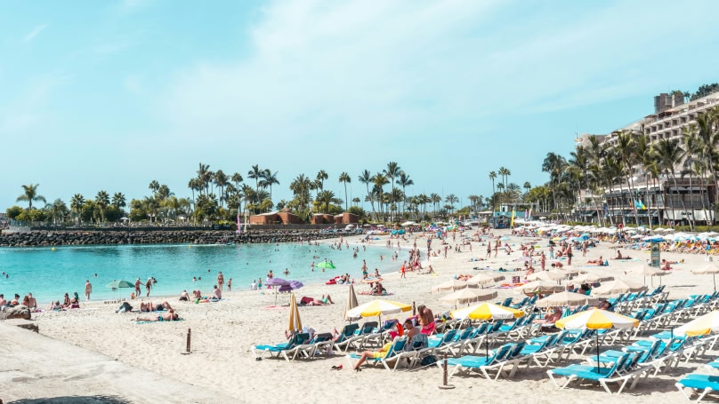 una spiaggia soleggiata con sabbia bianca e mare blu