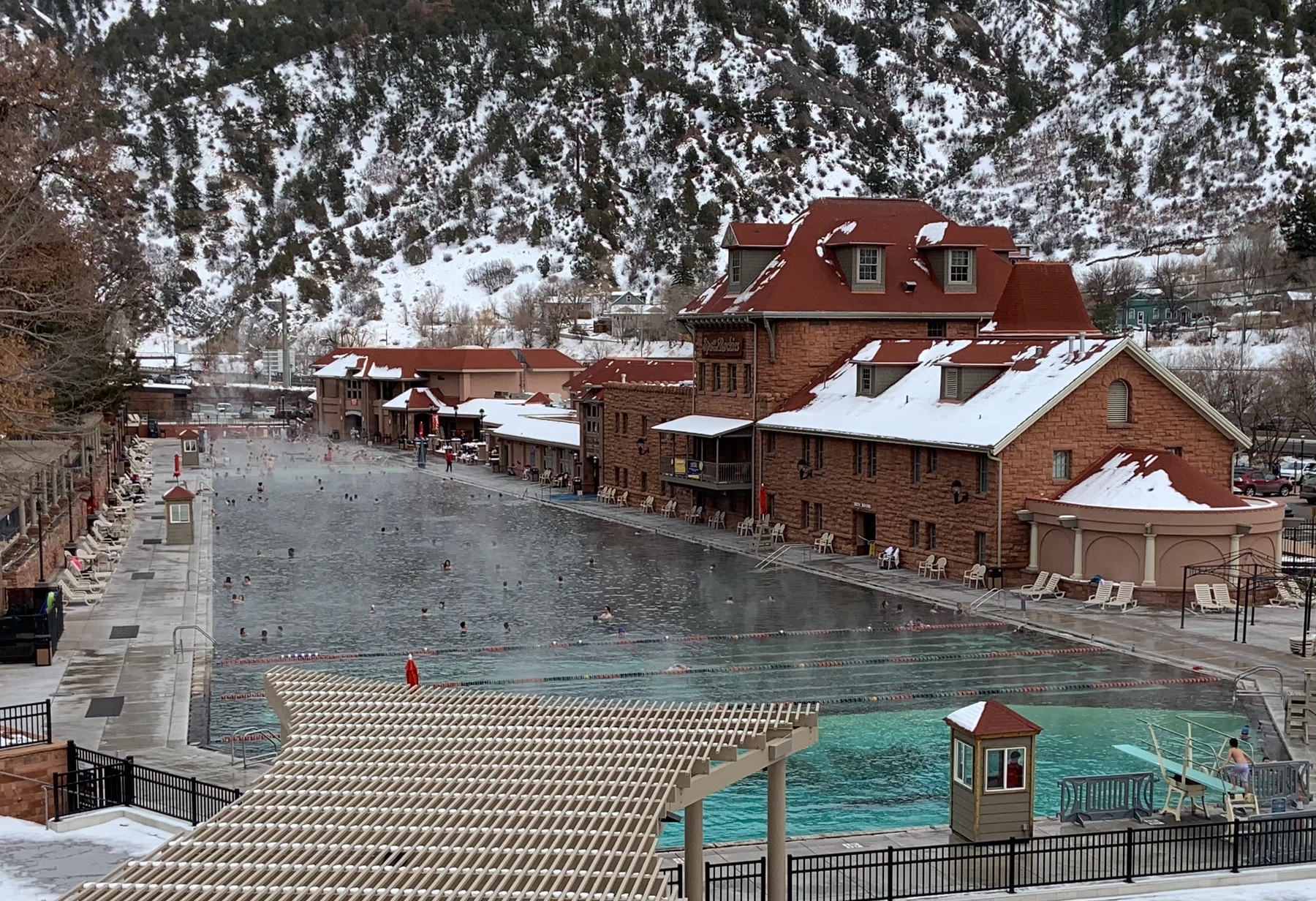 A red brick building overlooking a large steaming hot spring pool