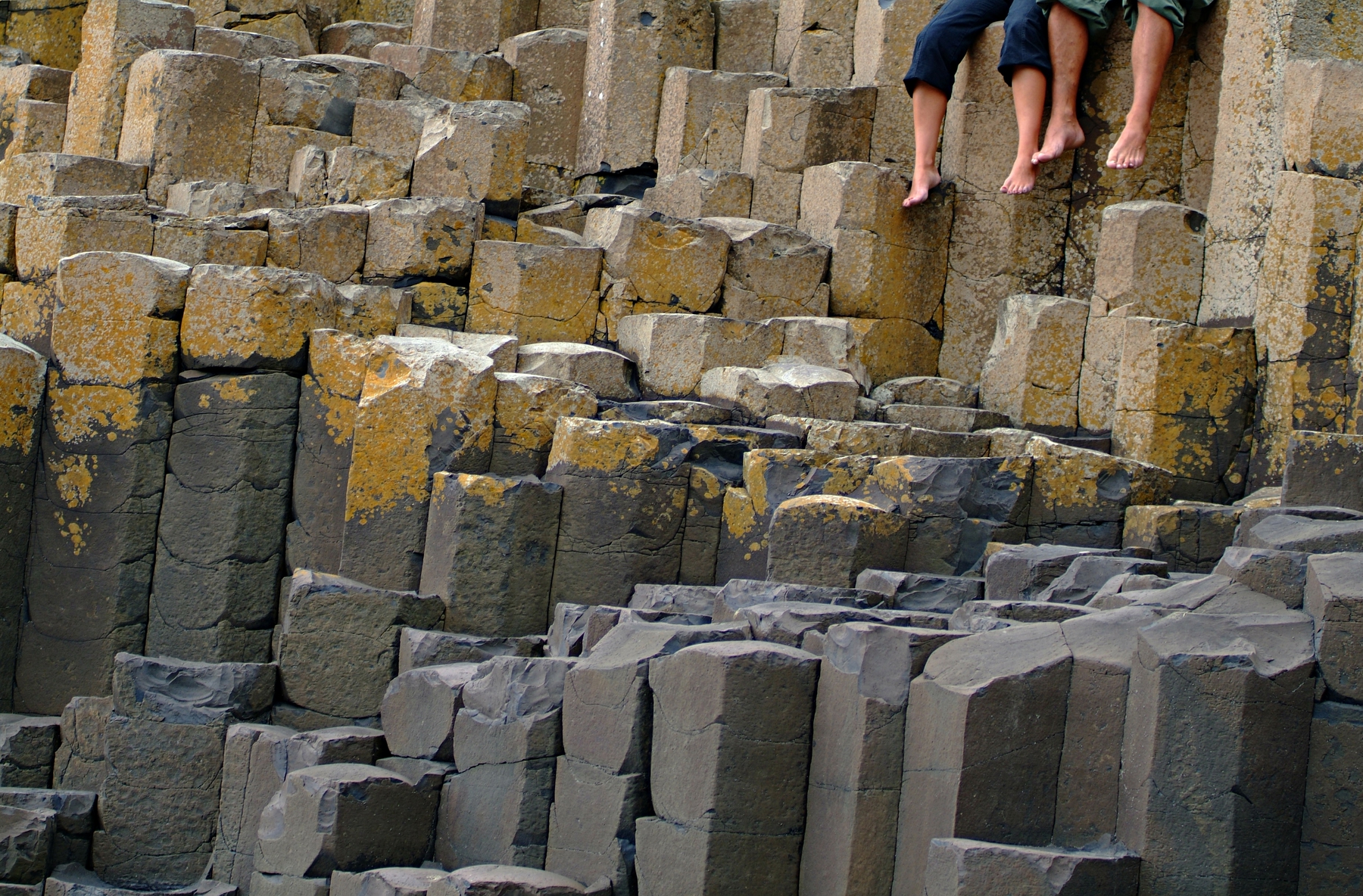 Couple sitting on the Giant's Causeway, Causeway Coast, Northern Ireland