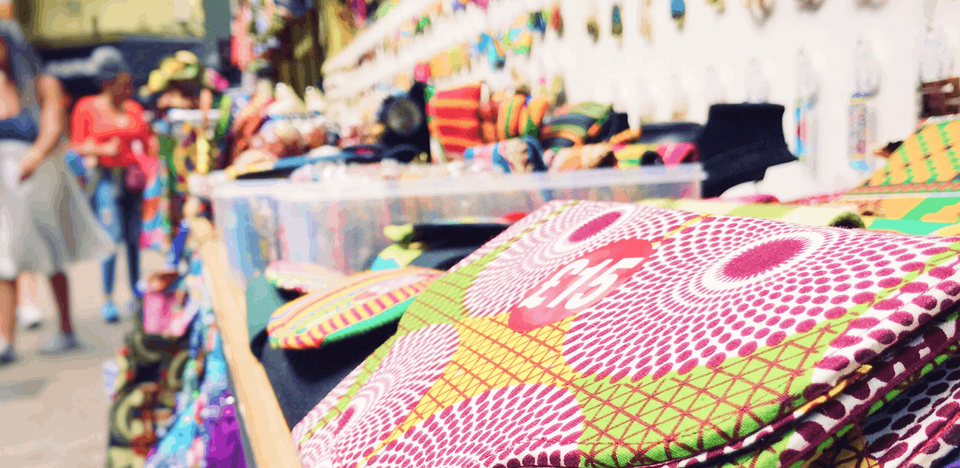 A vibrant close-up photograph capturing an array of colorful items displayed on a bustling market stall, creating a lively and dynamic scene.