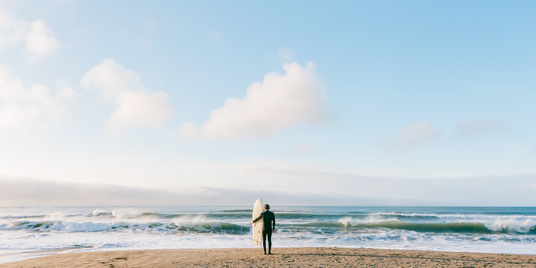 Person with a surfboard looking at the sea