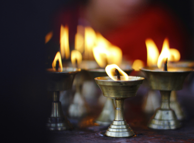 Intimate close-up of a group of small candles flickering within golden candle holders, radiating a warm and inviting glow.
