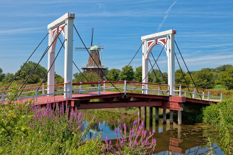Molen in groen landschap met op voorgrond ophaalbrug