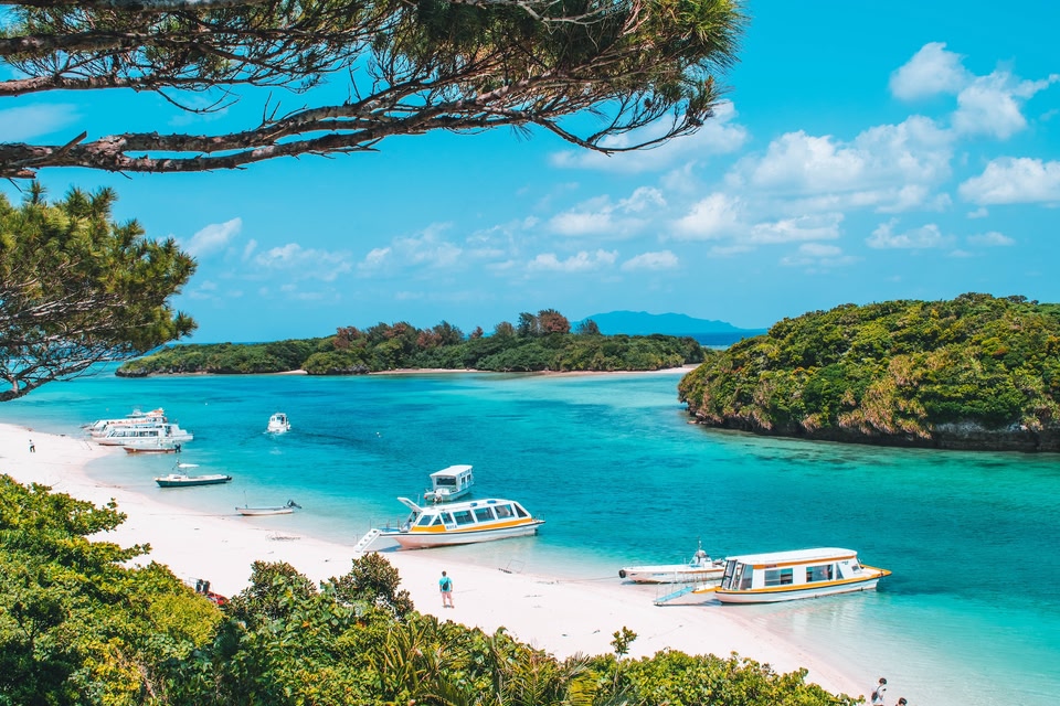 Turquoise water en bootjes op strand Okinawa