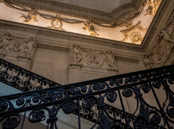 an image of a stair case in a building with decorative ceiling