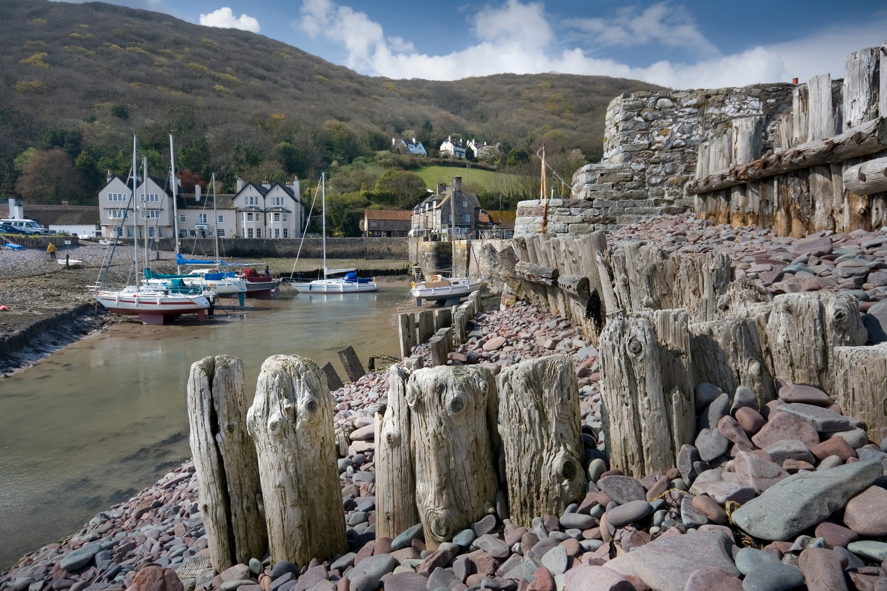 The harbour in Porlock, Exmoor, with tree-lined hills in the background and boats docked