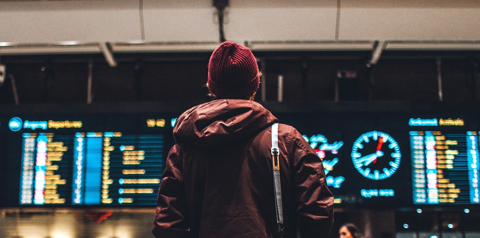 Man at airport looking at flight times