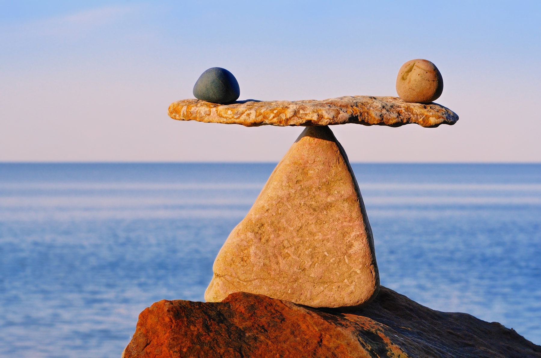 find your balance with transformative trips. rocks balancing by the water