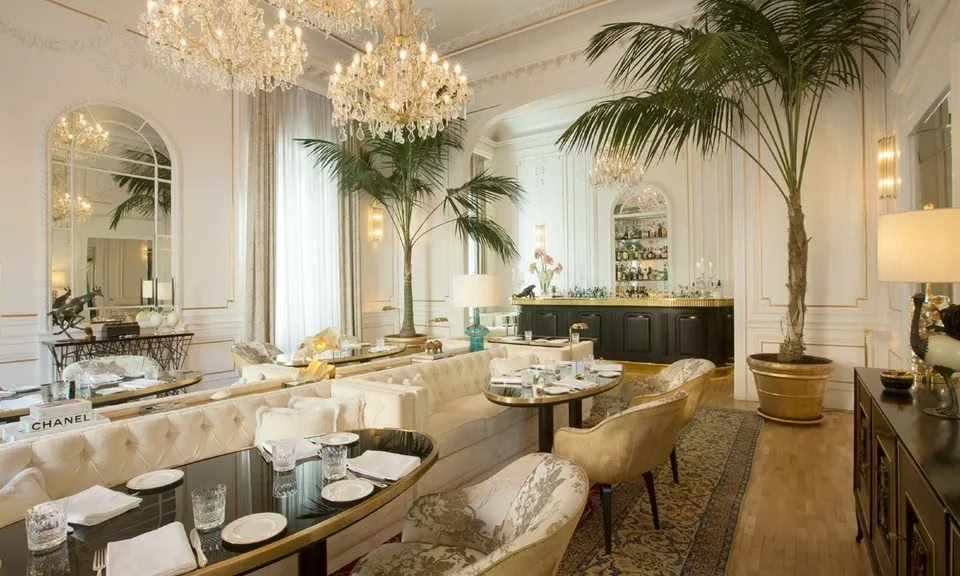 Comedor decorado con palmeras y lámparas de araña en el hotel boutique Palazzo Dama de Roma.